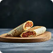 "Grilled chicken wrap with lettuce, tomato, and sauce on a wooden board with ketchup dip at Kyra Food Street Chennai"