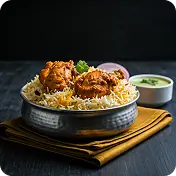 "Chicken biryani served in a metal bowl with raita and onions at Kyra Food Street Chennai"